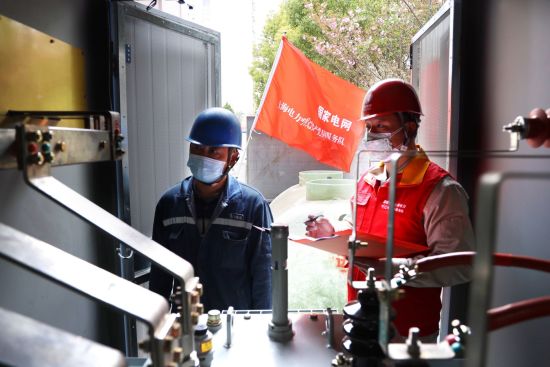 图：疫情期间，国网上海电力“明灯”共产党员服务队队员对杨浦区防疫配套新装供电设备进行验收。