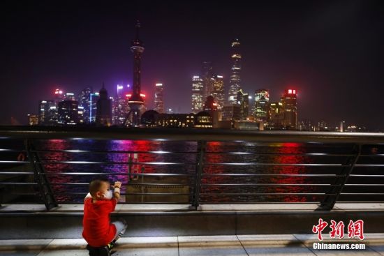 8月22日晚，上海�和ｉ_放部分�^域景�^照明，孩子在外��I江步道上游玩。中新社�者 殷立勤 �z