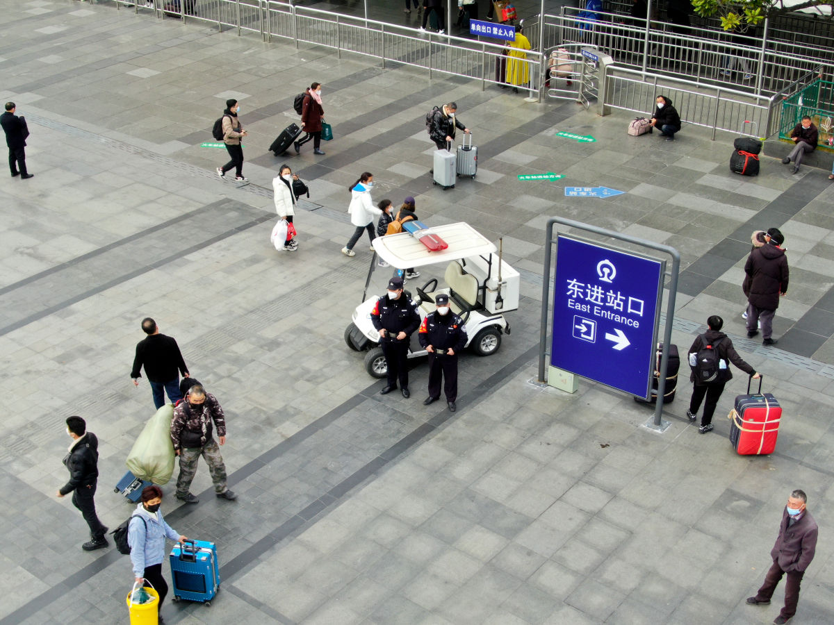 车站广场上，旅客步履匆匆，他们提着各式的行李，奔赴共同的方向。（摄影 陈莉丽）
