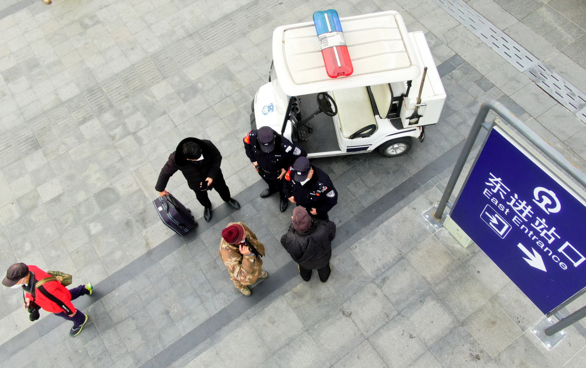 春运到来，车站民警比往常多了些许忙碌。广场上，两名民警在解答旅客的询问。（摄影 陈莉丽）